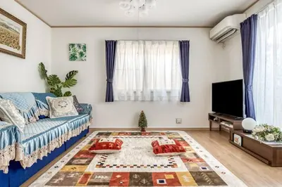 a living room with a blue couch and a tv at Ikebukuro Station 7 minutes by walk 110 sqm villa in Tokyo