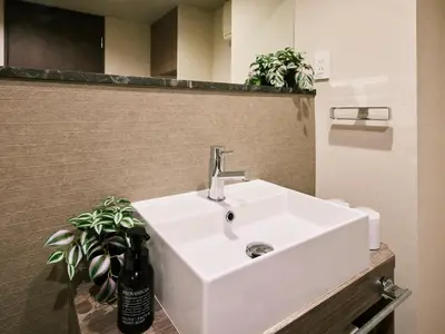 a white sink in a bathroom with two plants at Minn Ueno Iriya in Tokyo