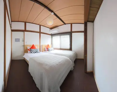 two beds in a room with a large window at \u30b2\u30b9\u30c8\u30cf\u30a6\u30b9\u3077\u308c\u305c\u3093\u3068 in Tokyo