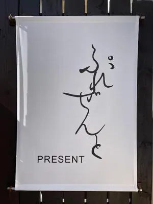 a sign that says present on a wall at \u30b2\u30b9\u30c8\u30cf\u30a6\u30b9\u3077\u308c\u305c\u3093\u3068 in Tokyo