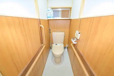 a bathroom with a toilet and wooden walls at Cozy house \u845b\u98fe in Tokyo