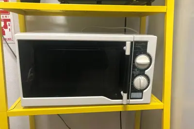 a microwave oven sitting on a yellow shelf at Cozy house \u845b\u98fe in Tokyo