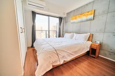 a bedroom with a large bed and a large window at Yoshitsuki kaku - Yoshitsuki Apart Hotel in Tokyo