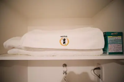 a pile of towels on a shelf in a bathroom at Yoshitsuki kaku - Yoshitsuki Apart Hotel in Tokyo