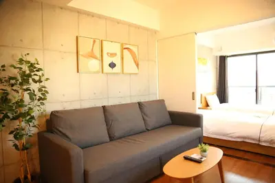 a living room with a couch and a bed at Yoshitsuki kaku - Yoshitsuki Apart Hotel in Tokyo