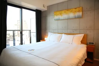 a bedroom with a large white bed with a window at Yoshitsuki kaku - Yoshitsuki Apart Hotel in Tokyo
