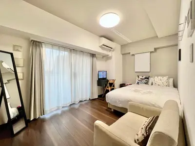 a bedroom with a bed and a couch and a window at Otsuka No3 Mansion#JR Yamanote Line Otsuka in Tokyo