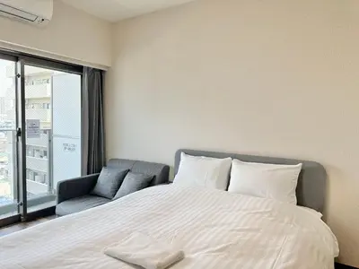 a bedroom with a large bed and a chair at Otsuka No3 Mansion#JR Yamanote Line Otsuka in Tokyo