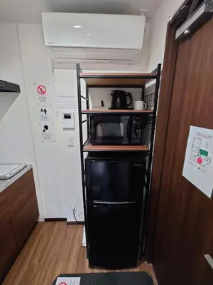 a small kitchen with a microwave on a shelf at 043AKIHABARA in Tokyo