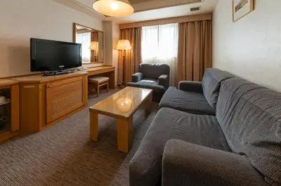 a living room with a couch and a flat screen tv at Hotel Siena in Tokyo