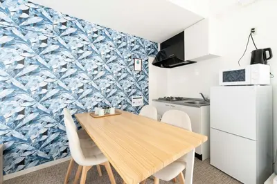 a kitchen and dining room with a wooden table and chairs at \u65b0\u5bbf\u307e\u30675\u5206 \u6771\u4e2d\u91ce\u99c5\u5f92\u6b692\u5206 \u685c\u306e\u540d\u6240\u4e07\u4e80\u6a4b\u8fd1\u304f \u6700\u59274\u4eba \u6d17\u6fef\u6a5f \u30c0\u30a4\u30cb\u30f3\u30b0 ILIMA Higashi Nakano in Tokyo