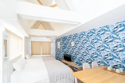 a bedroom with two beds and a desk and a table at \u65b0\u5bbf\u307e\u30675\u5206 \u6771\u4e2d\u91ce\u99c5\u5f92\u6b692\u5206 \u685c\u306e\u540d\u6240\u4e07\u4e80\u6a4b\u8fd1\u304f \u6700\u59274\u4eba \u6d17\u6fef\u6a5f \u30c0\u30a4\u30cb\u30f3\u30b0 ILIMA Higashi Nakano in Tokyo