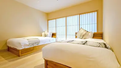 a bedroom with two beds and a large window at Stay SAKURA Tokyo Asakusa Yokozuna Hotel in Tokyo