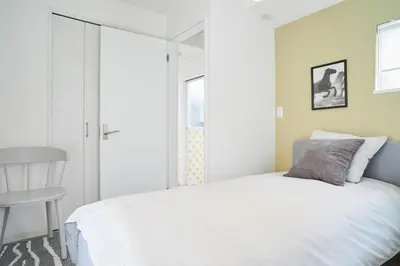 a bedroom with a white bed and a chair at Beautiful Villa in Shinjuku Shin-OKubo 6minutes walk B in Tokyo