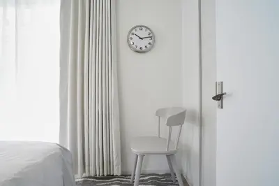 a room with a chair and a clock on the wall at Beautiful Villa in Shinjuku Shin-OKubo 6minutes walk B in Tokyo