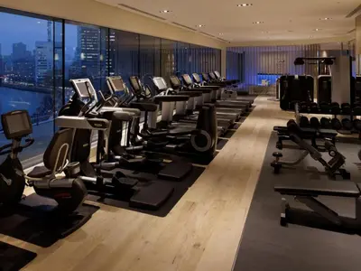 a gym with a row of treadmills and machines at Palace Hotel Tokyo in Tokyo