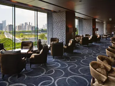 a hotel lobby with chairs and tables and large windows at Palace Hotel Tokyo in Tokyo