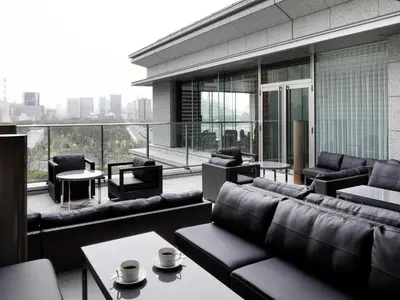 a living room with couches and tables on a balcony at Palace Hotel Tokyo in Tokyo