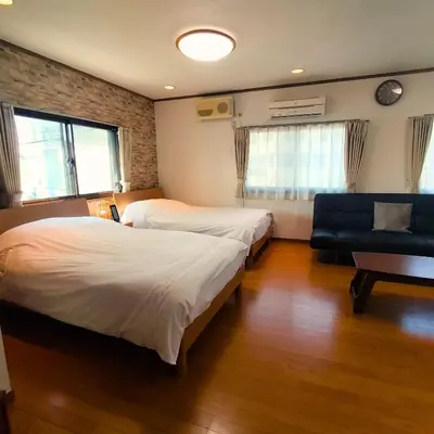a hotel room with two beds and a couch at STATION SIDE113 in Tokyo