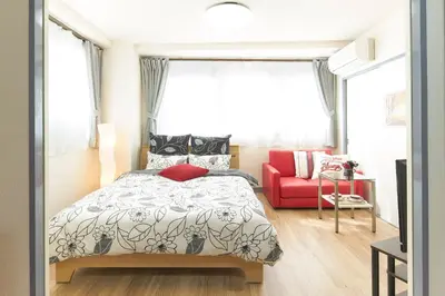 a bedroom with a bed and a red couch at ESPERANZA103 \u5e83\u3044\u7dba\u9e97\u5feb\u9069\u9ad8\u901fWiFi in Tokyo