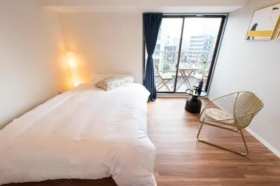 a bedroom with a bed and a chair and a window at TORA HOTEL Tokyo Skytree \u5bc5\u30db\u30c6\u30eb \u30b9\u30ab\u30a4\u30c4\u30ea\u30fcG in Tokyo