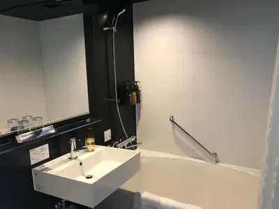 a bathroom with a sink and a bath tub at Hotel Resol Ueno in Tokyo