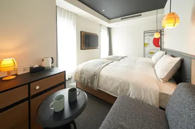 a bedroom with a bed and a table and a couch at Hotel Resol Ueno in Tokyo