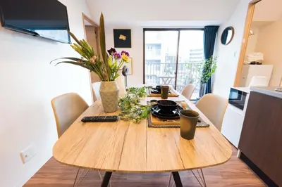 a wooden table with flowers on it in a kitchen at TORA HOTEL Tokyo Skytree \u5bc5\u30db\u30c6\u30eb \u30b9\u30ab\u30a4\u30c4\u30ea\u30fcE in Tokyo