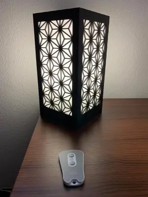 a remote control sitting on a table next to a lamp at Shinjuku Miyabi Residence in Tokyo