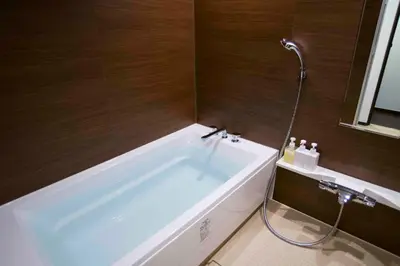 a white bath tub in a bathroom with a shower at Shinjuku Miyabi Residence in Tokyo