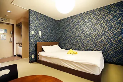 a bedroom with a bed with a blue patterned wall at Asakusa Japanese Style Stay with Futon & Beds in Tokyo
