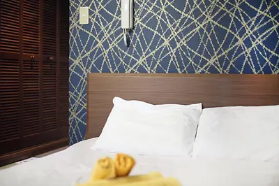 a bed with white pillows and a blue wall at Asakusa Japanese Style Stay with Futon & Beds in Tokyo