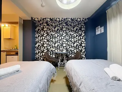 a room with two beds and a table with chairs at Asakusa Japanese Style Stay with Futon & Beds in Tokyo