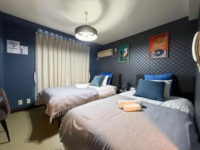 two beds in a room with blue walls at Asakusa Japanese Style Stay with Futon & Beds in Tokyo