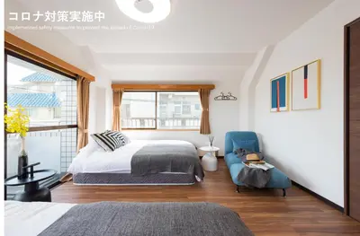 a bedroom with a bed and a blue chair at TORA HOTEL Tokyo-Rikugienn \u5bc5\u30db\u30c6\u30eb \u516d\u7fa9\u5712 D in Tokyo