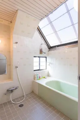 a bathroom with a bath tub and a skylight at TORA HOTEL Tokyo-Rikugienn \u5bc5\u30db\u30c6\u30eb \u516d\u7fa9\u5712 D in Tokyo