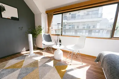 a bedroom with two white chairs and a large window at TORA HOTEL Tokyo-Rikugienn \u5bc5\u30db\u30c6\u30eb \u516d\u7fa9\u5712 D in Tokyo