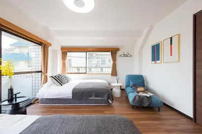 a bedroom with a bed and a blue chair at TORA HOTEL Tokyo-Rikugienn \u5bc5\u30db\u30c6\u30eb \u516d\u7fa9\u5712 D in Tokyo
