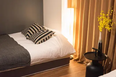 a bed with two pillows on it in a bedroom at TORA HOTEL Tokyo-Rikugienn \u5bc5\u30db\u30c6\u30eb \u516d\u7fa9\u5712 C in Tokyo