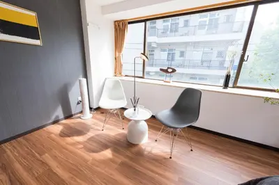 a living room with two chairs and a window at TORA HOTEL Tokyo-Rikugienn \u5bc5\u30db\u30c6\u30eb \u516d\u7fa9\u5712 C in Tokyo
