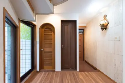 a hallway with a brown door and a window at TORA HOTEL Tokyo-Rikugienn \u5bc5\u30db\u30c6\u30eb \u516d\u7fa9\u5712 C in Tokyo