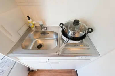 a kitchen sink with a pot on a stove at TORA HOTEL Tokyo-Rikugienn \u5bc5\u30db\u30c6\u30eb \u516d\u7fa9\u5712 C in Tokyo