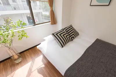 a room with a bed with a pillow and a window at TORA HOTEL Tokyo-Rikugienn \u5bc5\u30db\u30c6\u30eb \u516d\u7fa9\u5712 B in Tokyo
