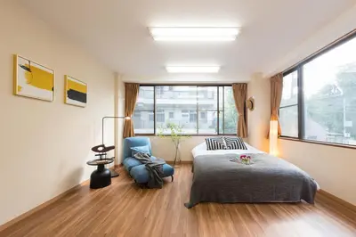 a bedroom with a bed and a chair and a window at TORA HOTEL Tokyo-Rikugienn \u5bc5\u30db\u30c6\u30eb \u516d\u7fa9\u5712 B in Tokyo