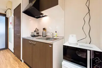a small kitchen with a sink and a microwave at TORA HOTEL Tokyo-Rikugienn \u5bc5\u30db\u30c6\u30eb \u516d\u7fa9\u5712 B in Tokyo