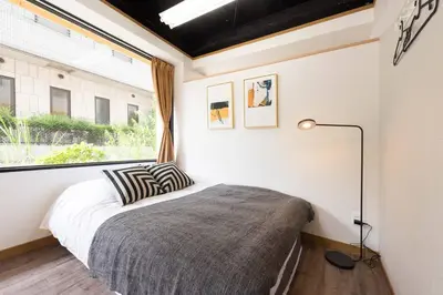 a bedroom with a bed and a large window at TORA HOTEL Tokyo-Rikugienn \u5bc5\u30db\u30c6\u30eb \u516d\u7fa9\u5712 A in Tokyo