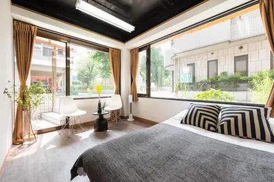 a bedroom with a large window and a bed at TORA HOTEL Tokyo-Rikugienn \u5bc5\u30db\u30c6\u30eb \u516d\u7fa9\u5712 A in Tokyo