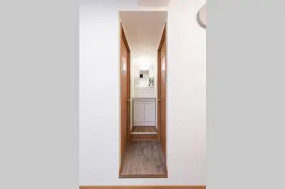a hallway leading into a bathroom with a mirror at TORA HOTEL Tokyo-Rikugienn \u5bc5\u30db\u30c6\u30eb \u516d\u7fa9\u5712 A in Tokyo
