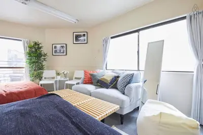 a living room with a couch and a chair at TORA HOTEL Tokyo-kitaueno \u5bc5\u30db\u30c6\u30eb\u5317\u4e0a\u91ce in Tokyo