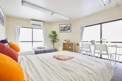 a bedroom with two beds and a dining room at TORA HOTEL Tokyo-kitaueno \u5bc5\u30db\u30c6\u30eb\u5317\u4e0a\u91ce in Tokyo
